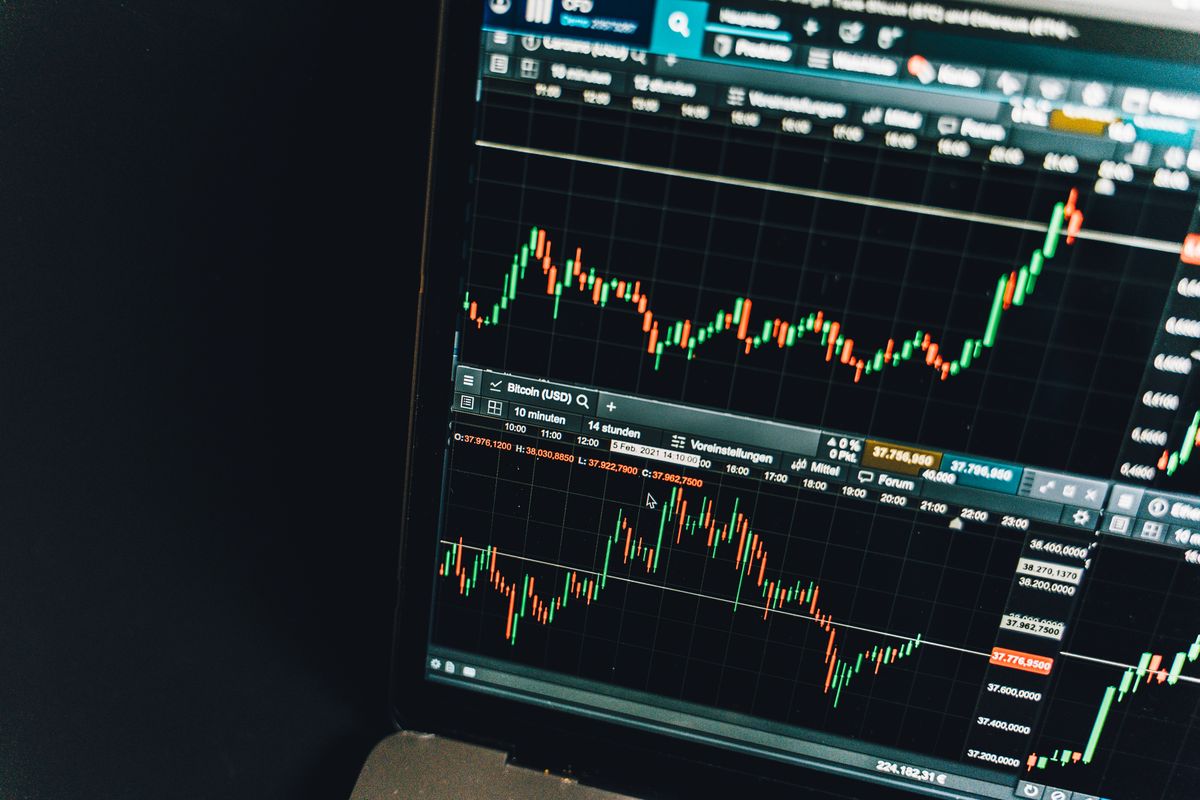 A dark screen with live market candles and trend lines