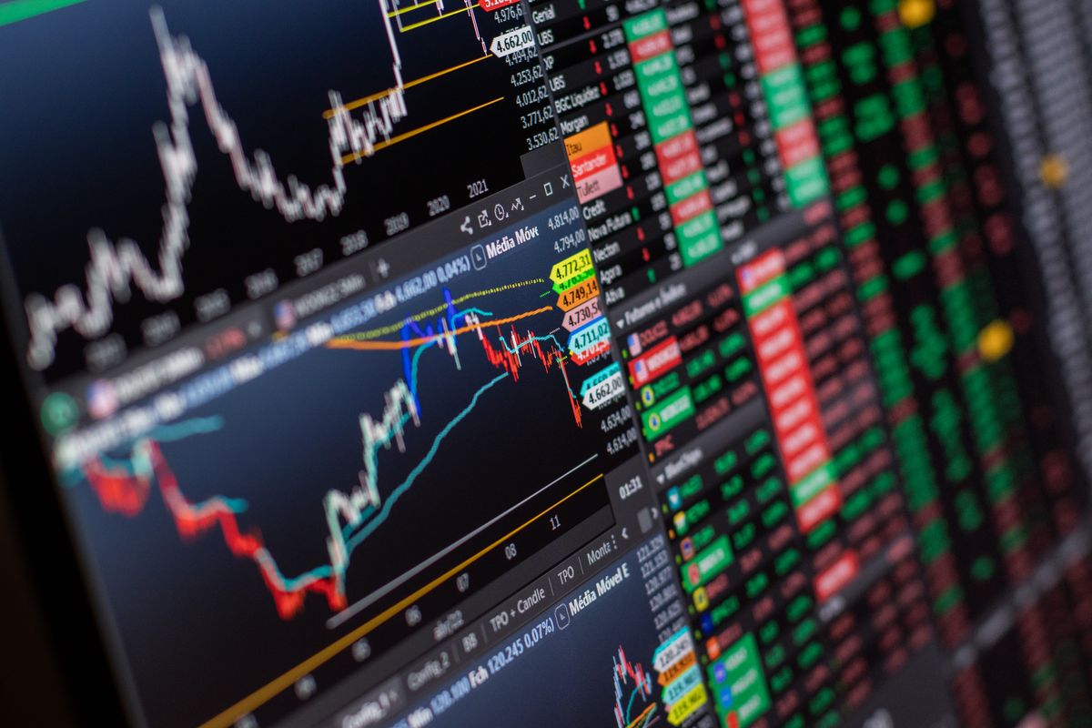 A laptop open to crypto market charts on a kitchen table — a normal life, not a trading floor